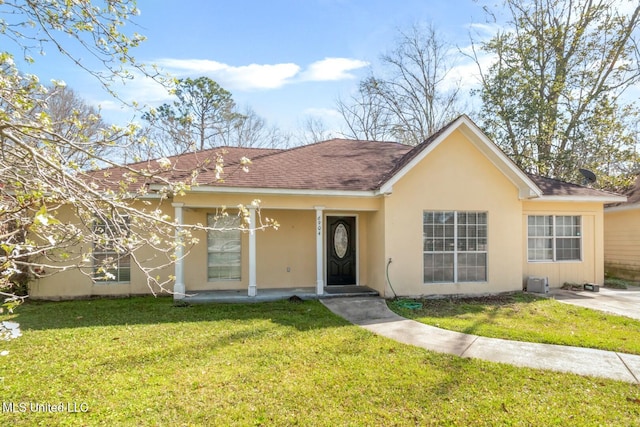 single story home with stucco siding, roof with shingles, and a front yard