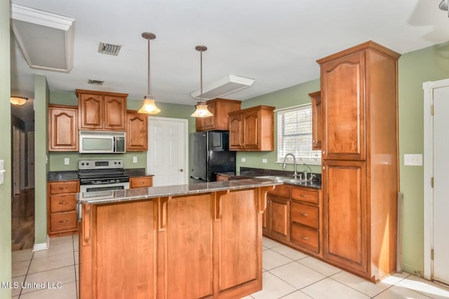 kitchen featuring visible vents, a breakfast bar, a sink, appliances with stainless steel finishes, and a center island