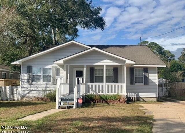 bungalow featuring covered porch and a front lawn