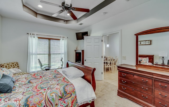 carpeted bedroom with crown molding, ceiling fan, and a raised ceiling