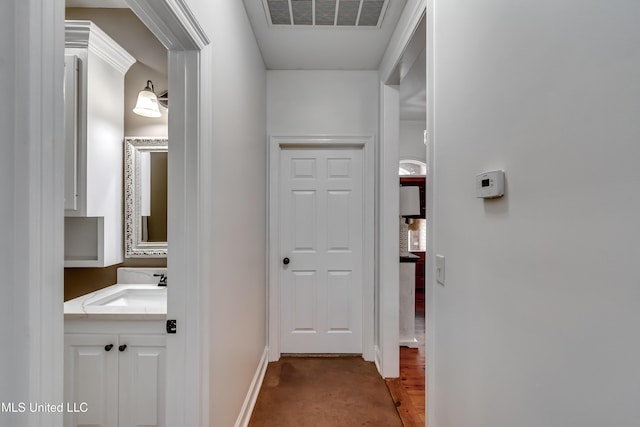 hallway with carpet and sink