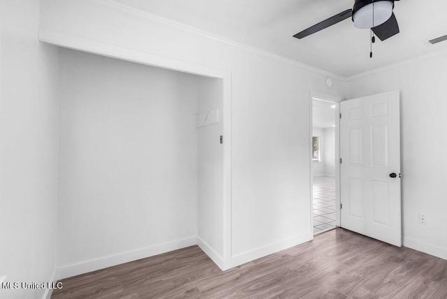 unfurnished bedroom featuring hardwood / wood-style flooring, ornamental molding, and ceiling fan