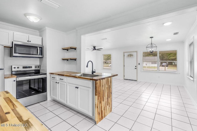 kitchen featuring appliances with stainless steel finishes, decorative light fixtures, sink, white cabinets, and kitchen peninsula