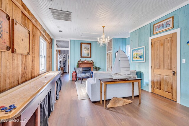 253 Sycamore St, Bay Saint Louis, MS 39520 - interior space with visible vents, wood walls, wood finished floors, and an inviting chandelier