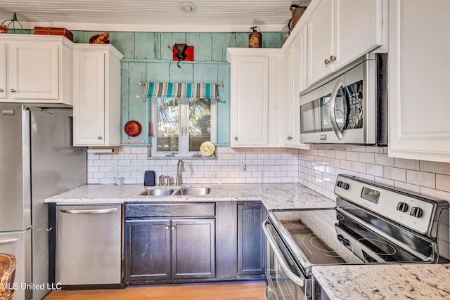 kitchen featuring sink, white cabinetry, decorative backsplash, and stainless steel appliances