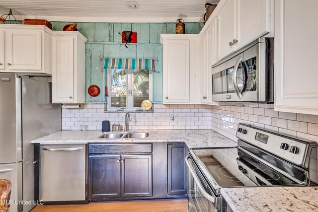 253 Sycamore St, Bay Saint Louis, MS 39520 - kitchen featuring a sink, white cabinetry, decorative backsplash, and stainless steel appliances