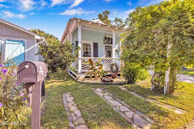 253 Sycamore St, Bay Saint Louis, MS 39520 - view of front of home featuring a porch and a front lawn