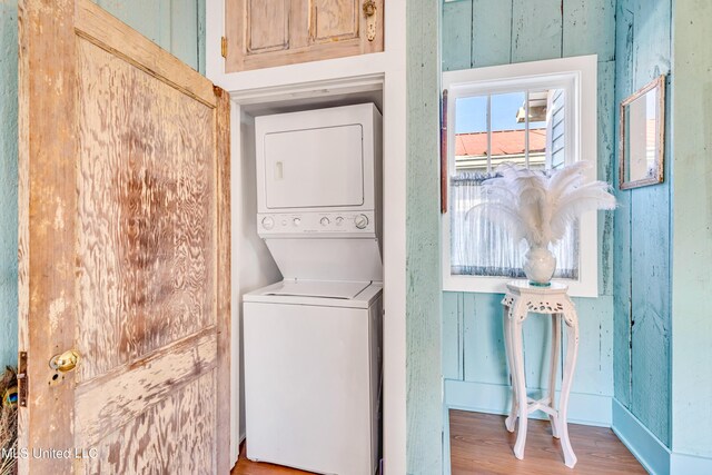 253 Sycamore St, Bay Saint Louis, MS 39520 - laundry area with baseboards, laundry area, stacked washer and dryer, and wood finished floors