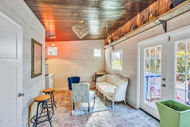 253 Sycamore St, Bay Saint Louis, MS 39520 - sitting room with wooden ceiling, plenty of natural light, brick patterned floor, and wood walls