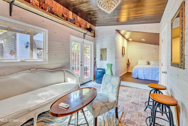 bedroom with a chandelier, wooden ceiling, vaulted ceiling, french doors, and wooden walls