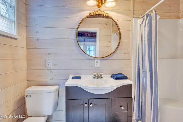 253 Sycamore St, Bay Saint Louis, MS 39520 - full bathroom with wooden walls, toilet, curtained shower, and vanity