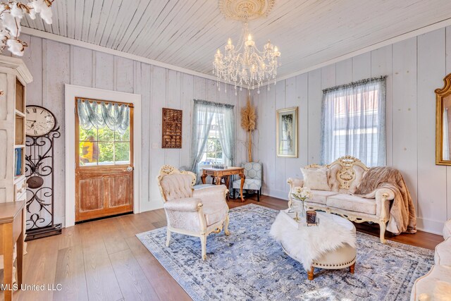 253 Sycamore St, Bay Saint Louis, MS 39520 - living area with light wood-type flooring, wood walls, wooden ceiling, a chandelier, and ornamental molding