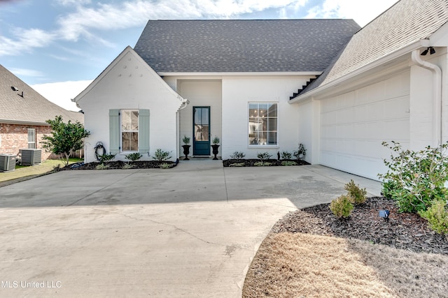 view of front of home with central AC and a garage