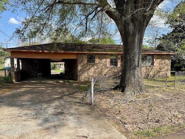 view of home's exterior with an attached carport, driveway, fence, and brick siding