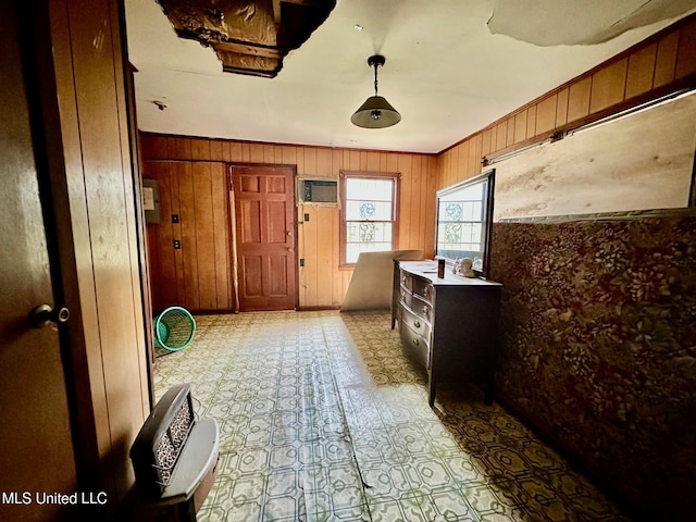 interior space featuring a wall unit AC, ornamental molding, wooden walls, and light floors
