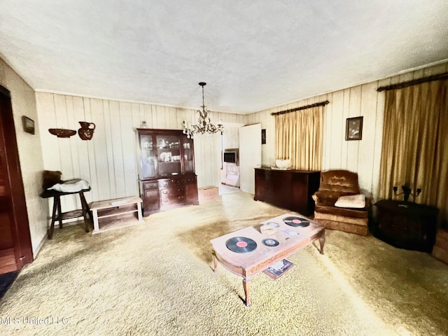 carpeted living area with a chandelier