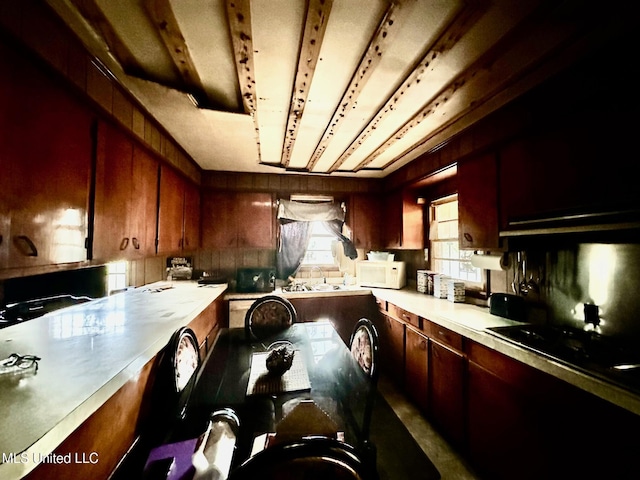 kitchen featuring light countertops, black gas stovetop, track lighting, and white microwave