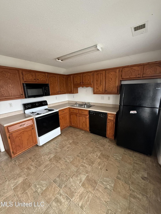 kitchen with sink, black appliances, and a textured ceiling