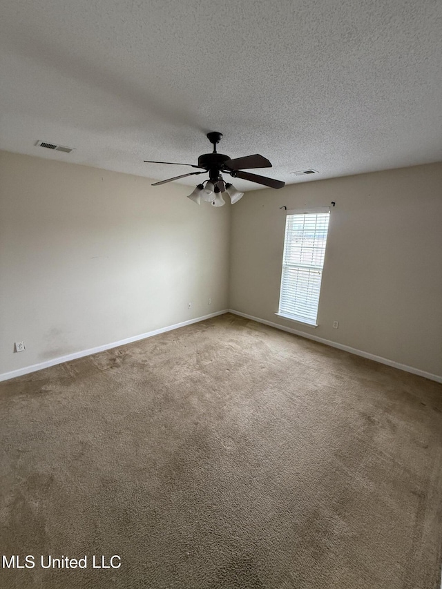 carpeted empty room with ceiling fan and a textured ceiling