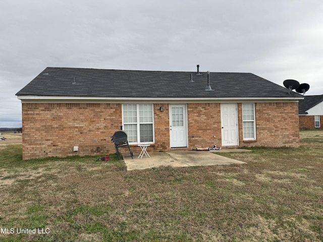 rear view of house featuring a lawn and a patio area