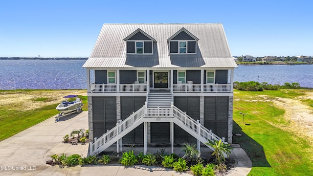 view of front of house featuring a front lawn and a water view