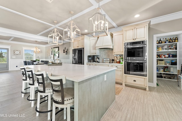 kitchen with custom exhaust hood, refrigerator with ice dispenser, pendant lighting, cream cabinetry, and double oven