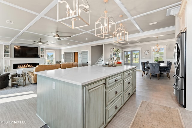 kitchen featuring coffered ceiling, stainless steel refrigerator, a center island, and hanging light fixtures