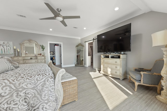 bedroom featuring ceiling fan, a barn door, a spacious closet, light hardwood / wood-style flooring, and a closet