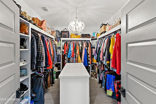 walk in closet with a notable chandelier