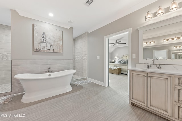 bathroom with vanity, tile walls, a tub to relax in, and ceiling fan