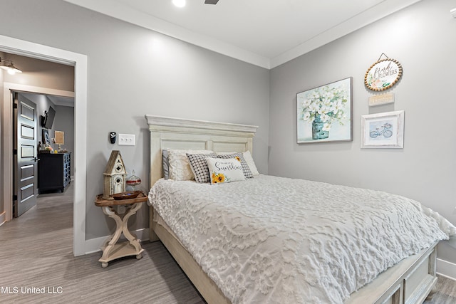 bedroom featuring ornamental molding and hardwood / wood-style flooring