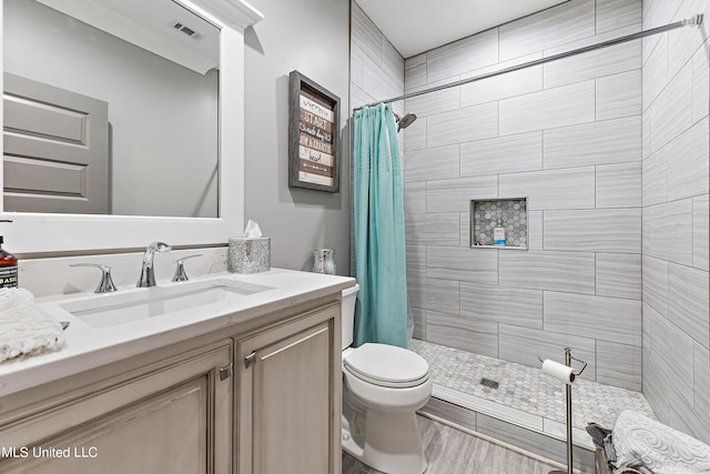 bathroom with vanity, curtained shower, hardwood / wood-style flooring, and toilet