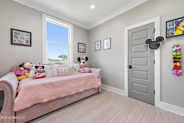 bedroom featuring light hardwood / wood-style floors and crown molding