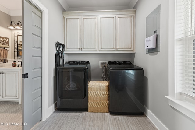 laundry room featuring cabinets, ornamental molding, electric panel, and washing machine and clothes dryer