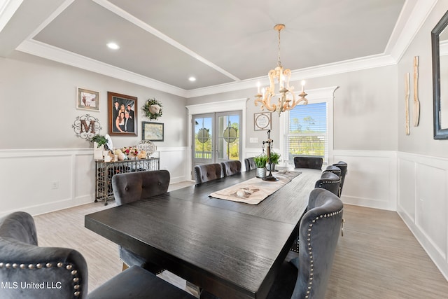 dining space featuring an inviting chandelier, crown molding, french doors, and light hardwood / wood-style flooring