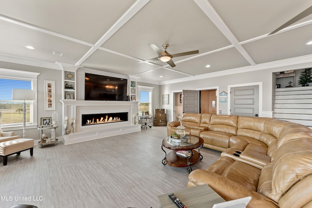 living room with coffered ceiling, ceiling fan, and a healthy amount of sunlight