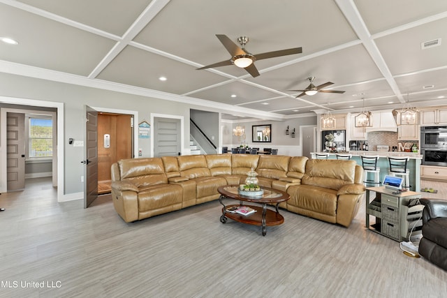 living room with crown molding, coffered ceiling, and ceiling fan