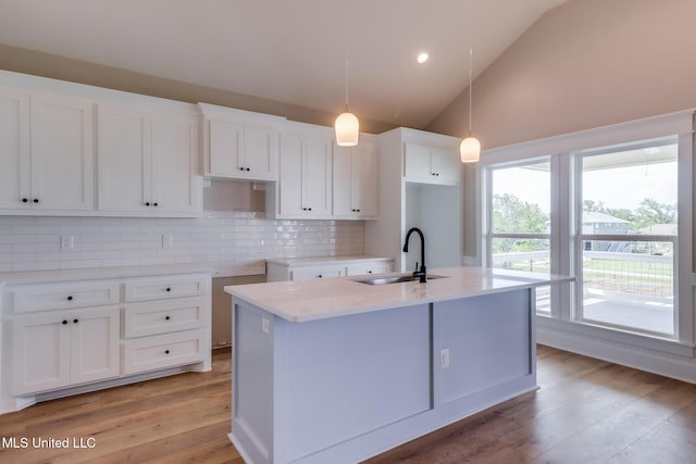 4054 Mallard St, Bay Saint Louis, MS 39520 - kitchen featuring a sink, a center island with sink, tasteful backsplash, white cabinetry, and light wood-style floors