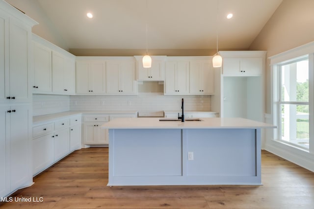 4054 Mallard St, Bay Saint Louis, MS 39520 - kitchen featuring lofted ceiling, tasteful backsplash, an island with sink, a sink, and recessed lighting