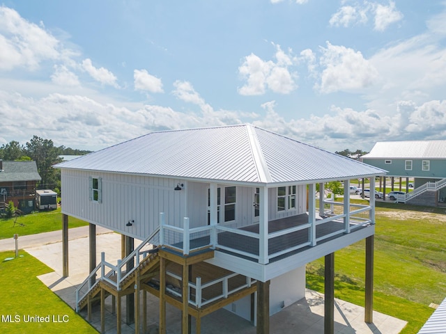 4054 Mallard St, Bay Saint Louis, MS 39520 - rear view of house with board and batten siding, a yard, and metal roof