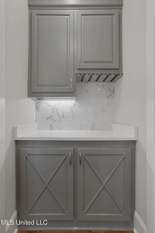 room details featuring wet bar, baseboards, and decorative backsplash