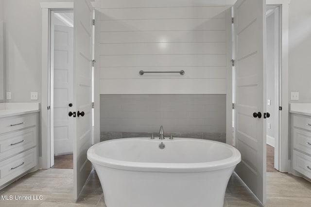 full bath featuring a freestanding bath and vanity