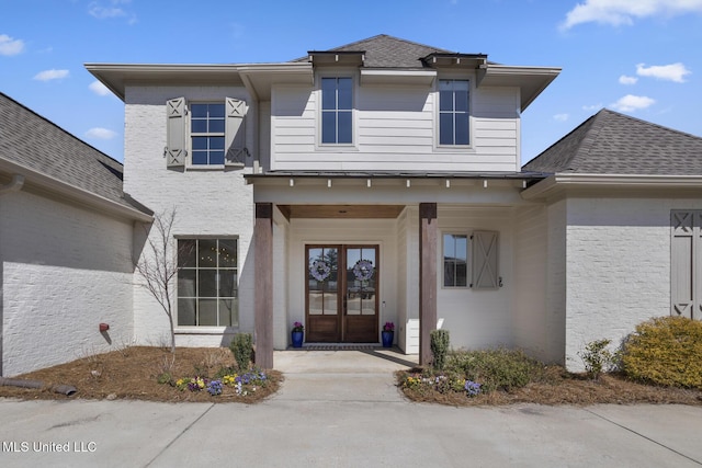 entrance to property featuring a shingled roof