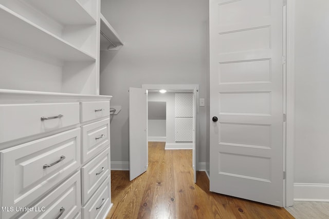 walk in closet with wood finished floors