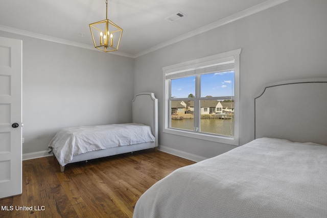 bedroom with baseboards, visible vents, ornamental molding, wood finished floors, and a chandelier