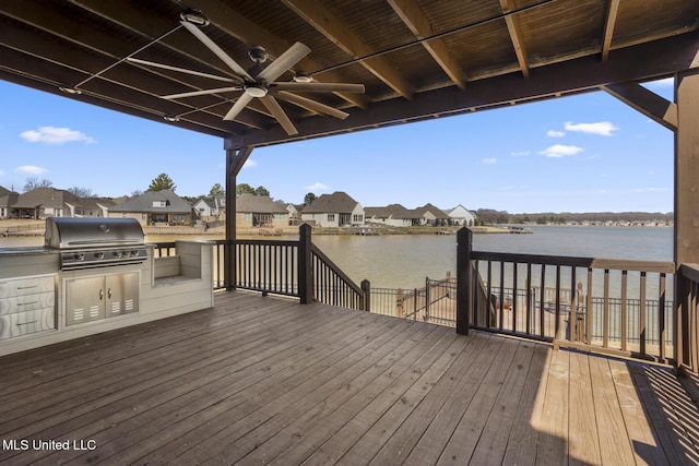 deck featuring a ceiling fan, a residential view, a water view, and grilling area