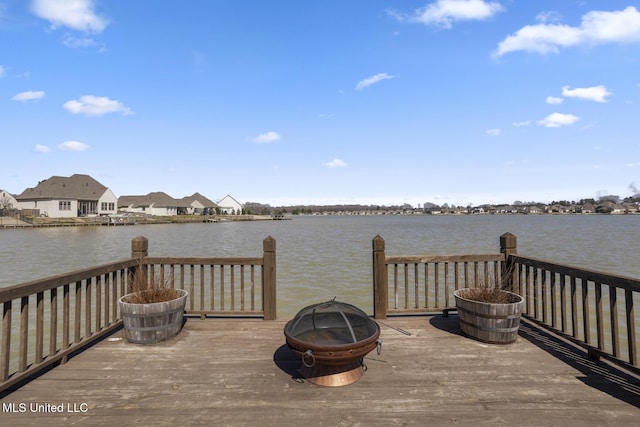 wooden deck with a fire pit and a water view