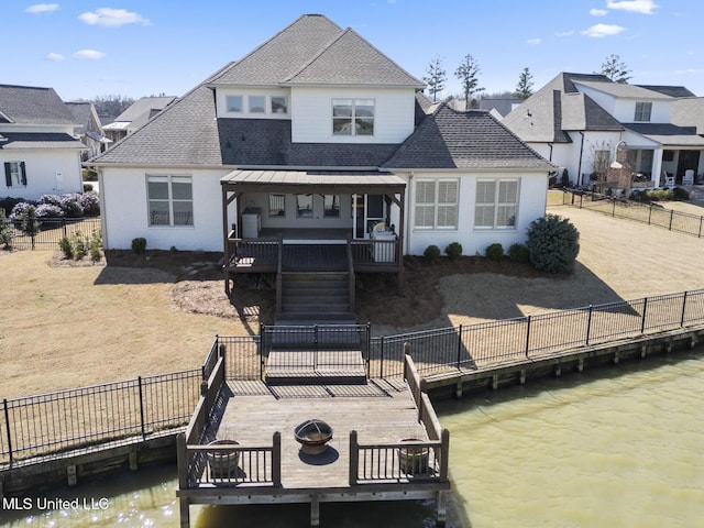 back of property featuring a fire pit, a fenced backyard, stairway, roof with shingles, and a wooden deck