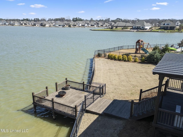 view of dock featuring a playground, a residential view, and a water view