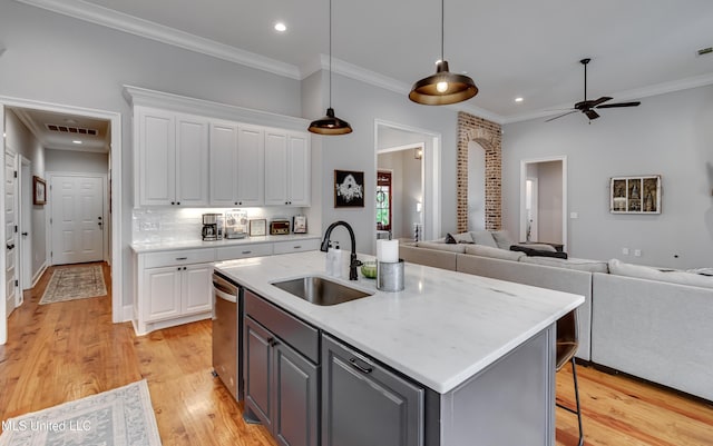 kitchen featuring white cabinetry, sink, and a kitchen island with sink